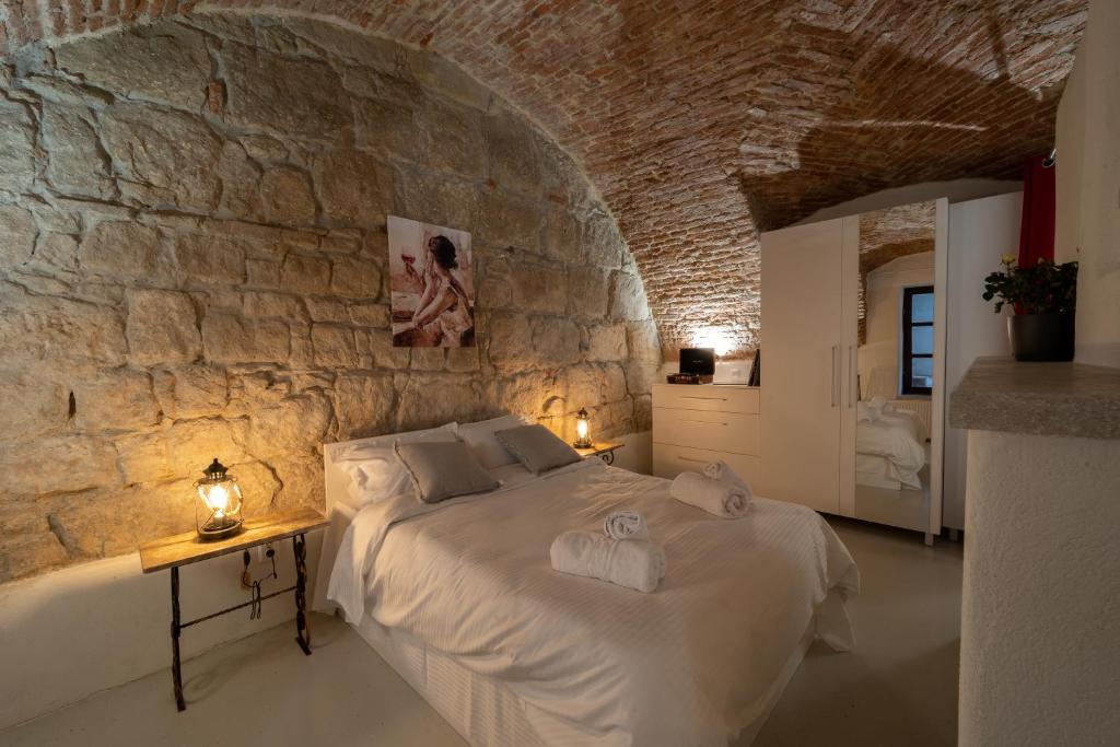 a bedroom with a bed in a stone wall at 5* luxury in Unirii square. in Cluj-Napoca