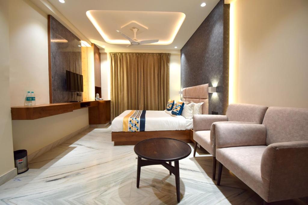 ナスドワーラにあるThe Sky Imperial Hotel Sugam - 10 Meters from Shrinathji Templeのベッドとソファ付きのホテルルーム