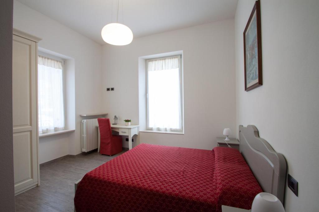 a bedroom with a red bed and a desk at Palazzo di Primavera Guest House in Caprino Veronese