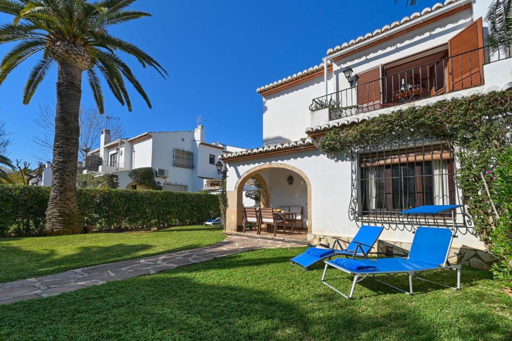 a house with two blue chairs in the yard at Casa Julieta in Jávea