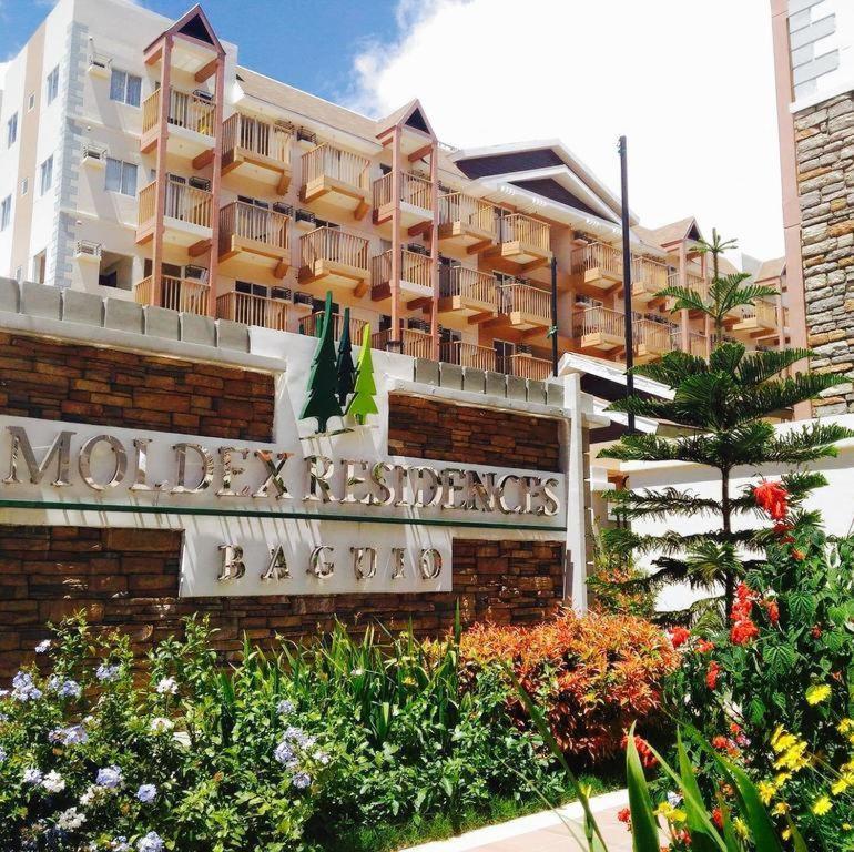 a large building with a sign in front of it at Cozy and Private Condo in Baguio in Baguio