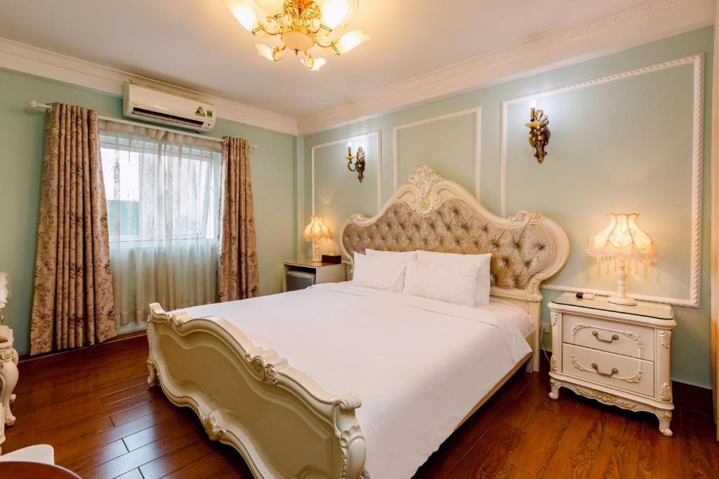 a bedroom with a large white bed and a window at Super OYO Capital O 1173 Le Grand Hanoi Hotel - The Ruby in Hanoi