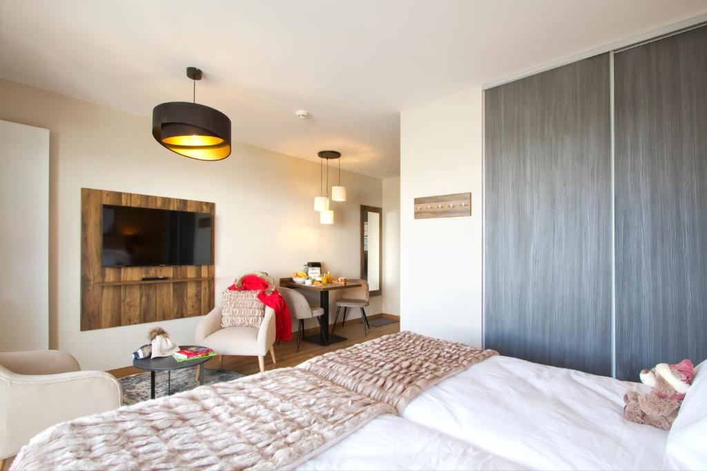 Кровать или кровати в номере Appart'Hôtel Prestige Odalys L'Eclose