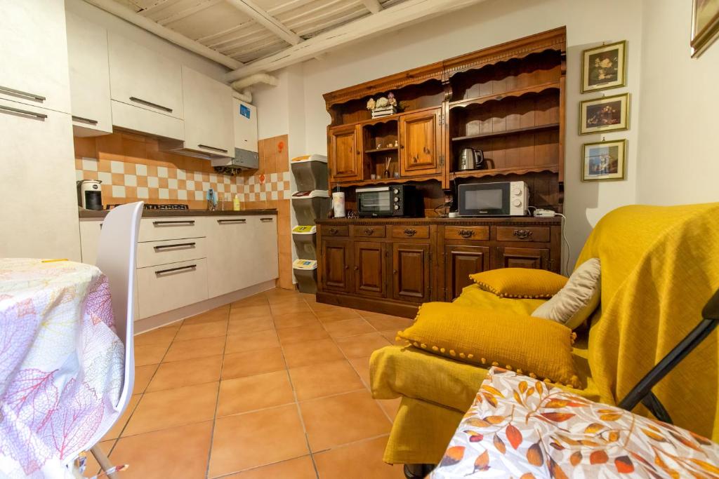 a kitchen with a yellow chair and a kitchen with cabinets at BIANCAROSA in Viterbo