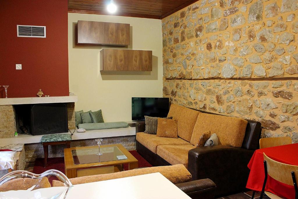 a living room with a couch and a stone wall at Snow story 1 -Elati, Trikala-2BD in Elati Trikalon