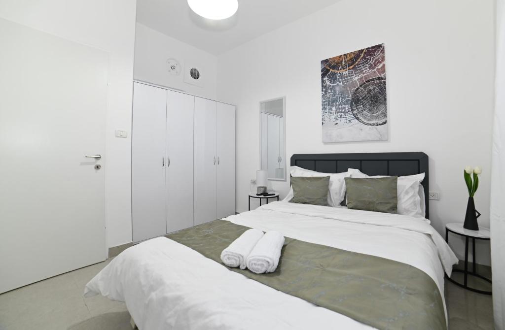 ein weißes Schlafzimmer mit einem großen Bett mit zwei Handtüchern darauf in der Unterkunft Kineret sheli- 4Bedrooms luxury apartment with stunning lake view in Tiberias