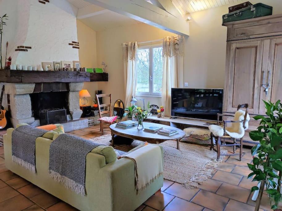 ein Wohnzimmer mit einem Sofa und einem Kamin in der Unterkunft Ahoma, séjour bien-être, calme et sérénité. in Labruguière