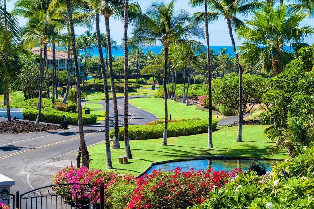 uitzicht op een park met palmbomen en een weg bij Shores At Waikoloa Beach Resort 332 in Waikoloa