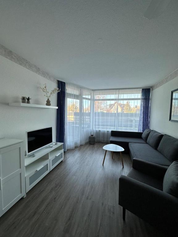 a living room with a couch and a tv at Strandhotel Wohnung 2 in Dahme