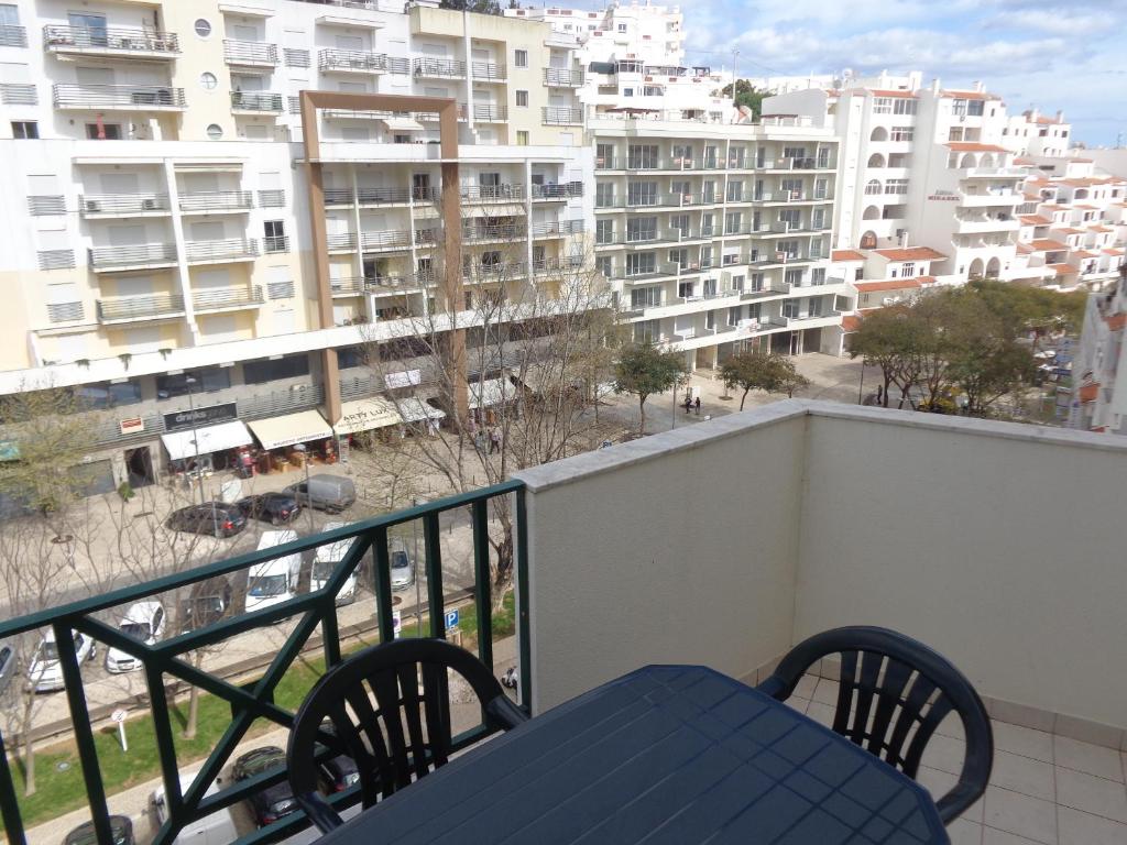 un balcone con tavolo blu, sedie e edifici di Apartamento Avenida da Liberdade ad Albufeira
