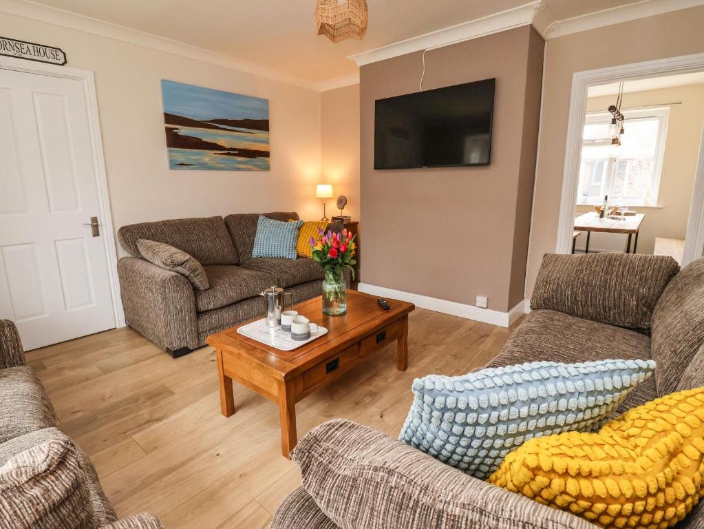 a living room with couches and a coffee table at The Beach Huts in Hornsea