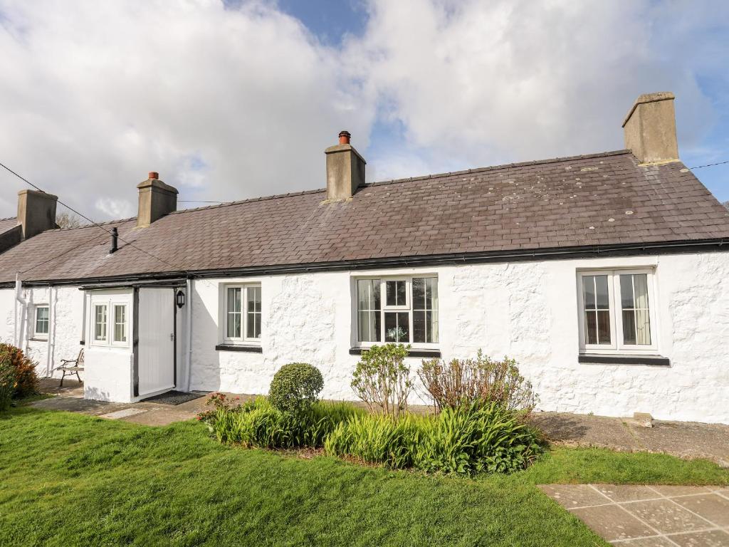 a white house with a black roof at Ty Hir in Llangoed