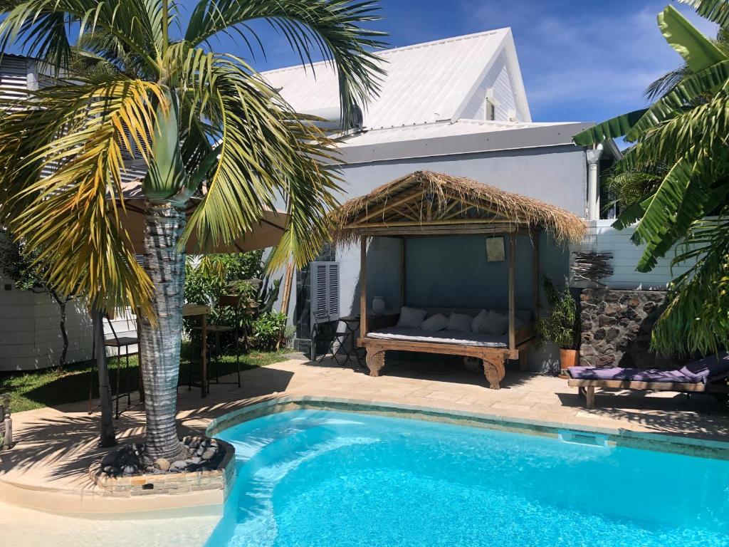 une villa avec une piscine à côté d'une maison dans l'établissement studio indépendant dans propriété avec piscine et wifi, à Saint-Gilles les Bains