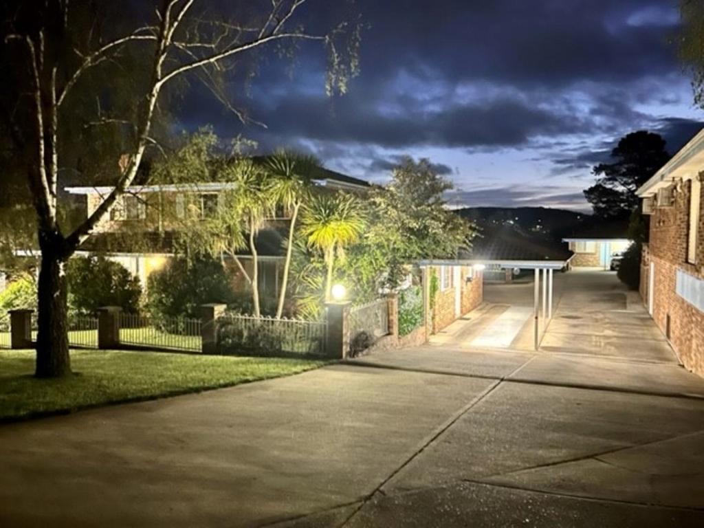 a house with lights on a street at night at Kinross Inn in Cooma
