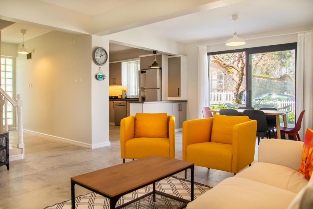 ein Wohnzimmer mit gelben Stühlen und einem Tisch in der Unterkunft Fully Furnished and Stylish Villa in Izmir in Izmir