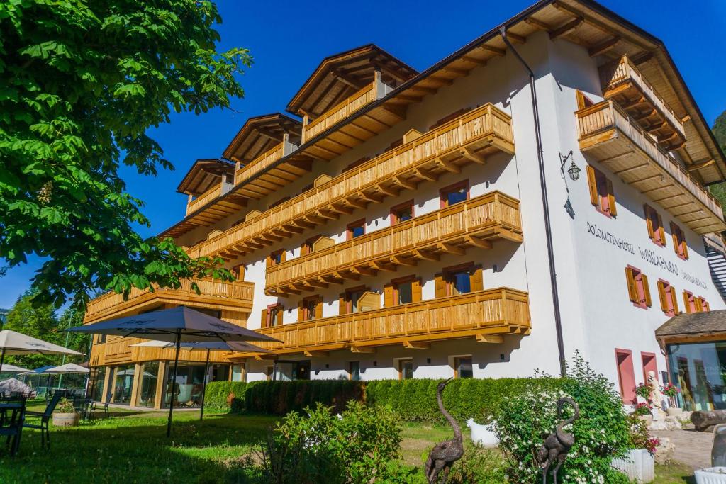 a building with wooden balconies on it at Dolomitenhotel Weisslahnbad in Tires