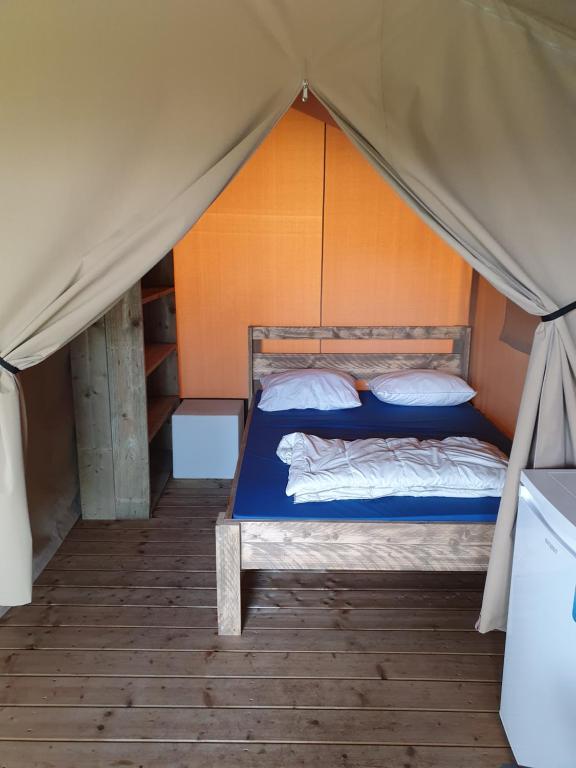 a bedroom with a bed in a tent at Safaritent 1 in Swalmen