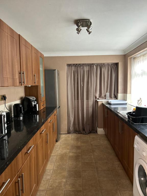 a large kitchen with wooden cabinets and a window at Village Rooms in Marton