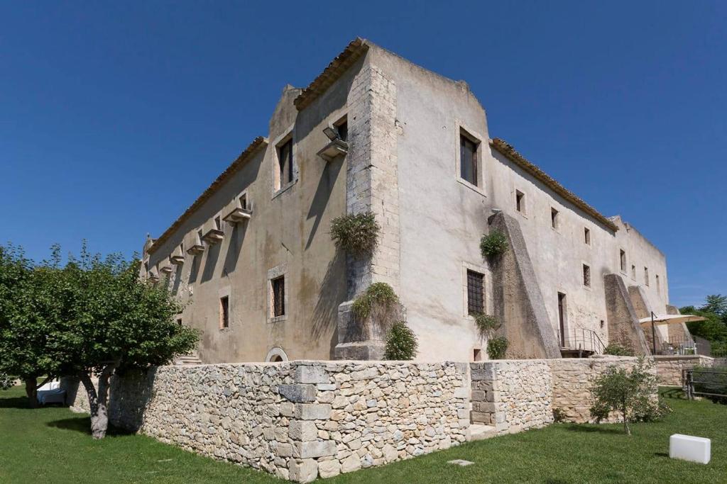 a large stone building with a stone wall at Antico Convento Dei Cappuccini in Ragusa