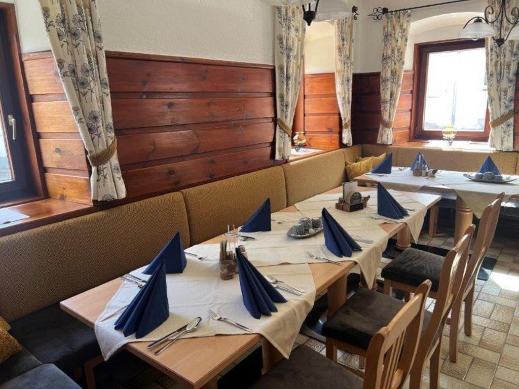 una fila di tavoli in un ristorante con tovaglioli blu di Gasthof Kögerlwirt a Göstling an der Ybbs