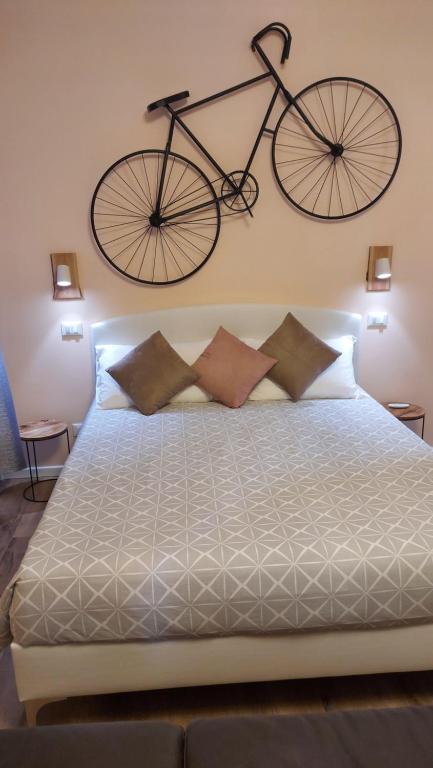 Glam Resort Luxury Lorenzo في لا سبيتسيا: معلقة الدراجة على الحائط فوق السرير