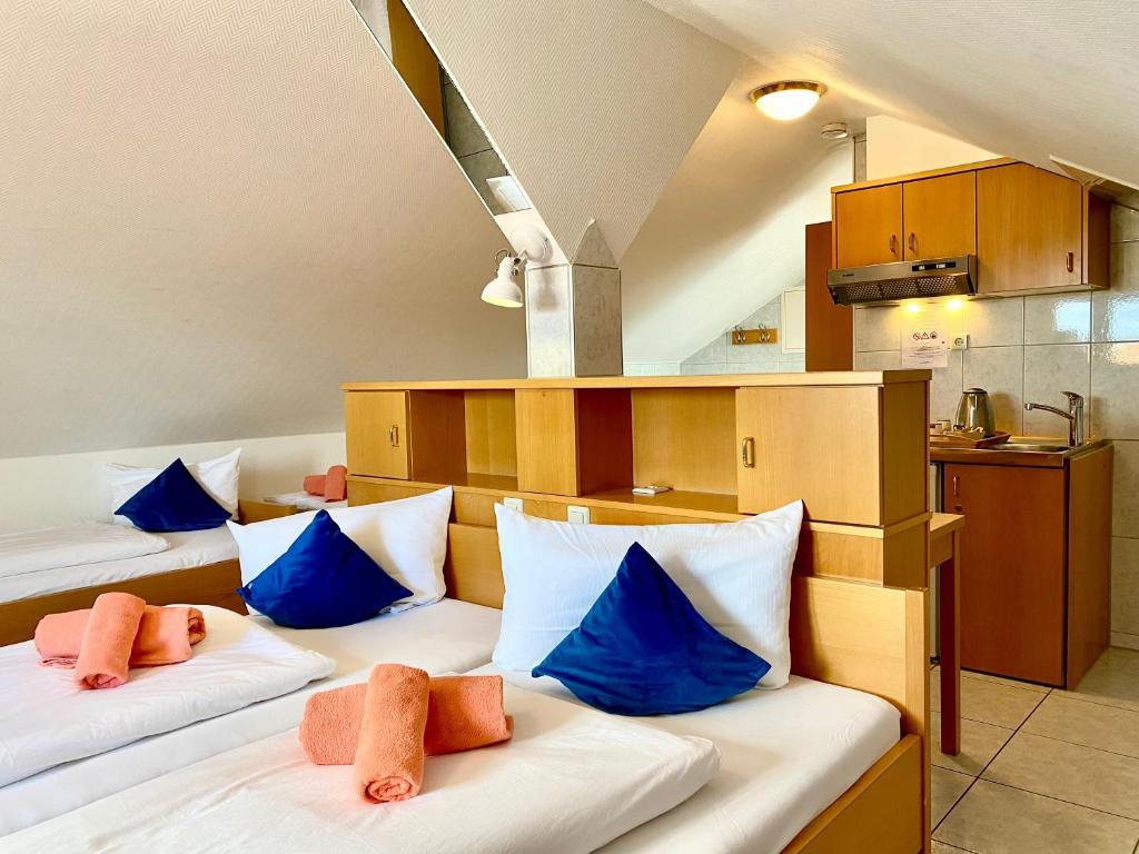 シュトゥットガルトにあるM ホテルの青い枕付きのベッド2台が備わる客室です。
