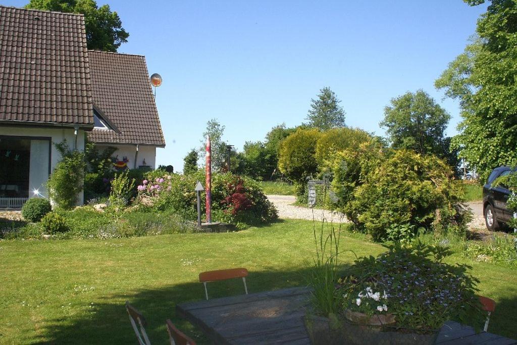 a yard with a house and a garden with flowers at Ferienwohnung Kobs in Ausacker