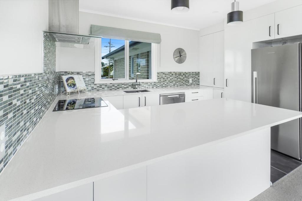 una cocina blanca con una gran encimera blanca en Home away from home! en Hamilton