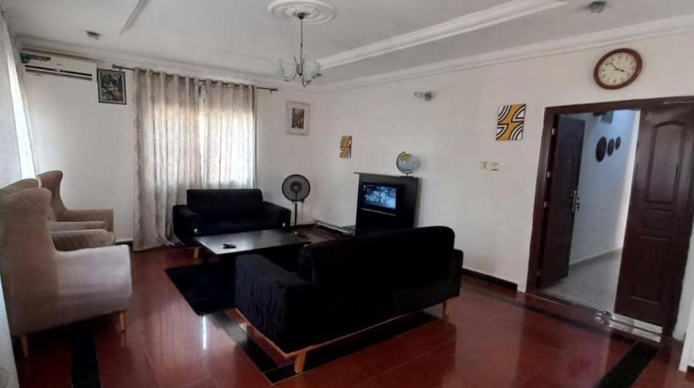 a living room with a couch and a tv at Arsenal's Lodge in Abuja