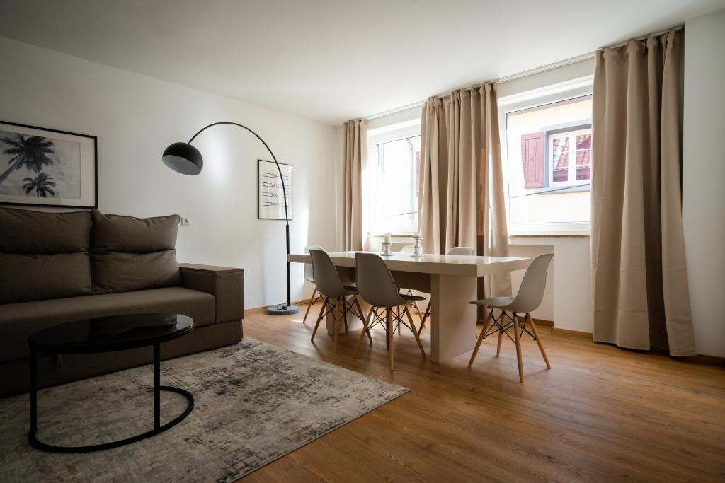 een woonkamer met een bank, een tafel en stoelen bij Old Town Apartment 2 rooms/baths in Düsseldorf