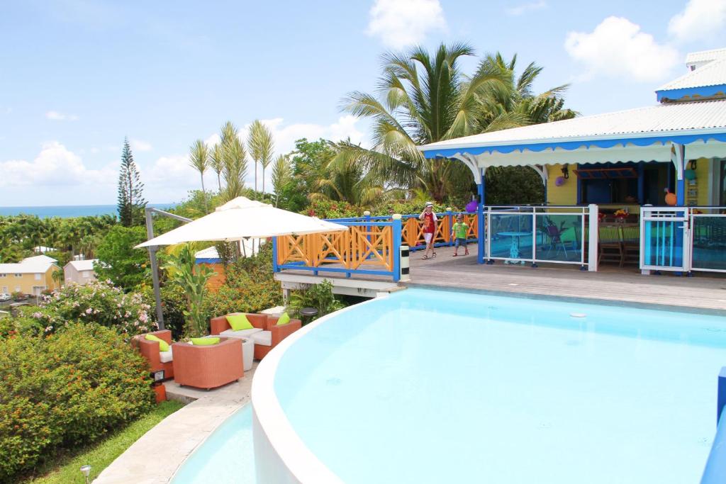 un complejo con piscina y restaurante en Villa TI JIMO, en Plessis-Nogent