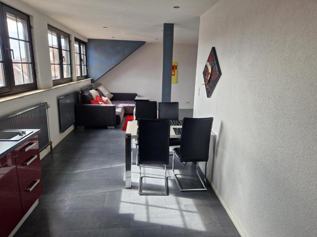 een woonkamer met een tafel en zwarte stoelen bij Wohnen auf Zeit City Speyer in Speyer