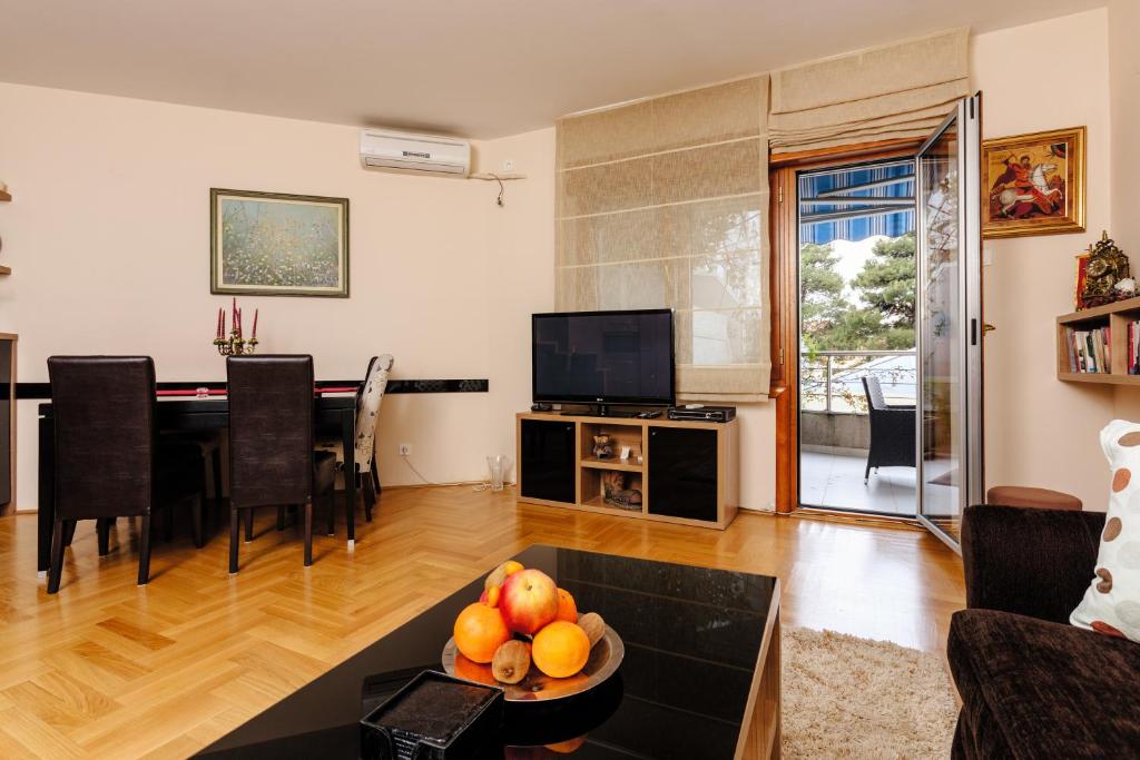 a living room with a table and a television at Apartment Sahala in Tivat