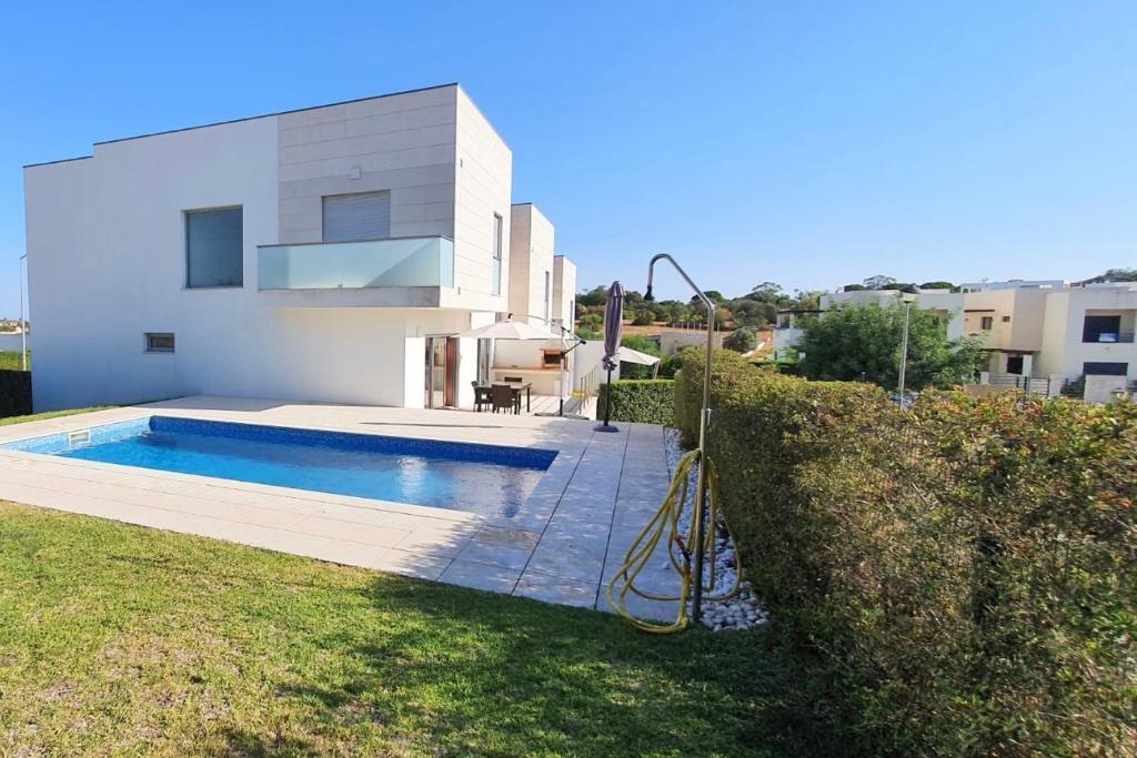 una piscina frente a una casa en Modern 3Bedroom Duplex W/Pool by LovelyStay en Alcantarilha