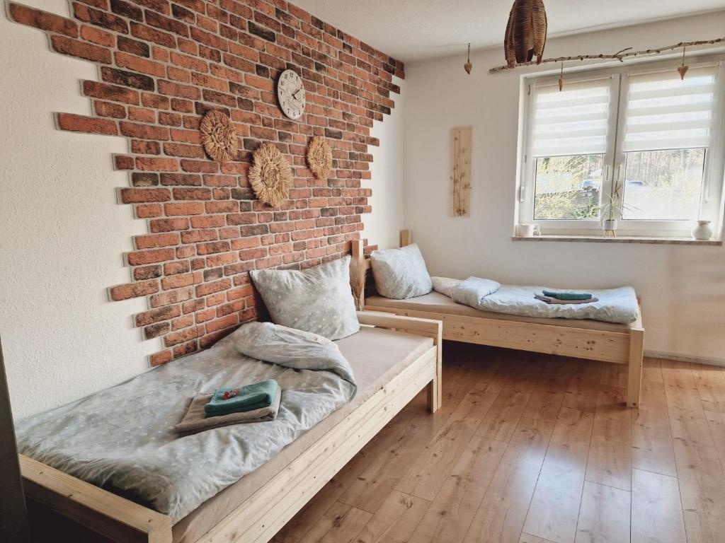 a room with two beds and a brick wall at Ferienwohnung Sunny in Mittenwalde