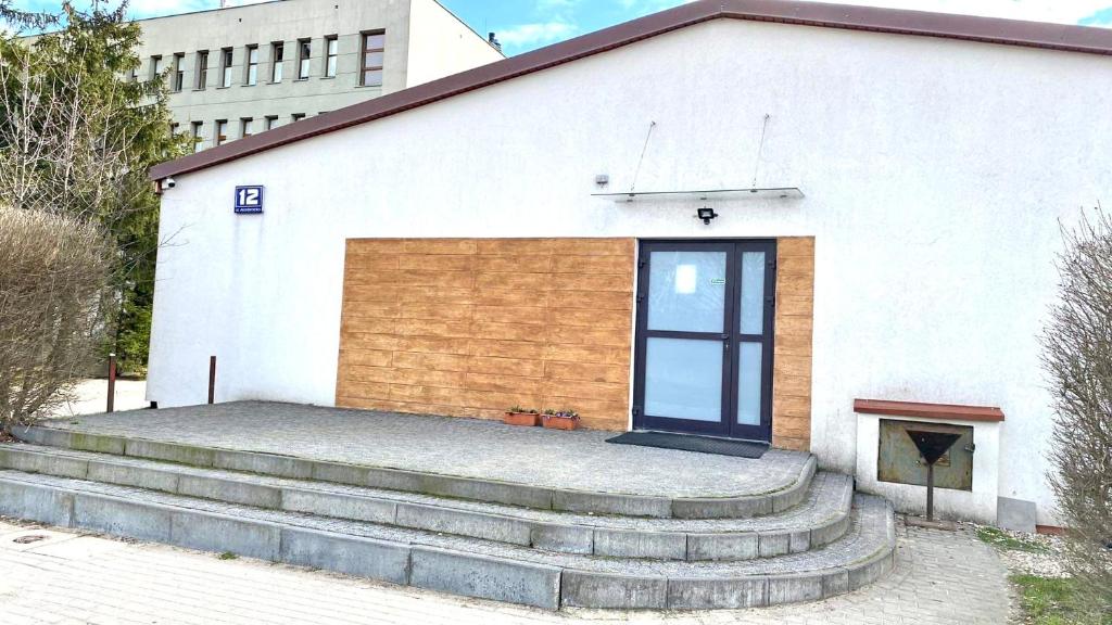 a white building with steps leading up to a door at AKADUS Noclegi in Łomża