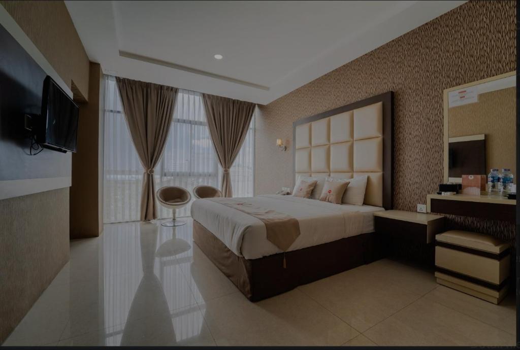 ナゴヤにあるOsaka Hotel Batamのベッドルーム(大型ベッド1台、テレビ付)