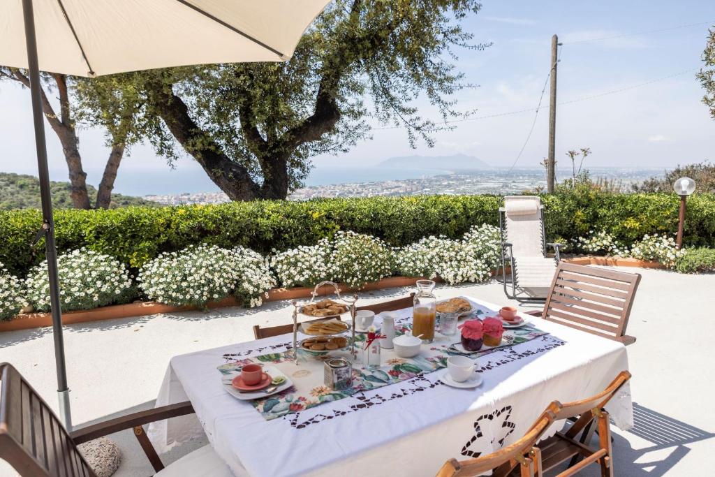 una mesa con un mantel blanco sobre una mesa con una sombrilla en Holidaycasa Circe - Con giardino vista mare, en Terracina