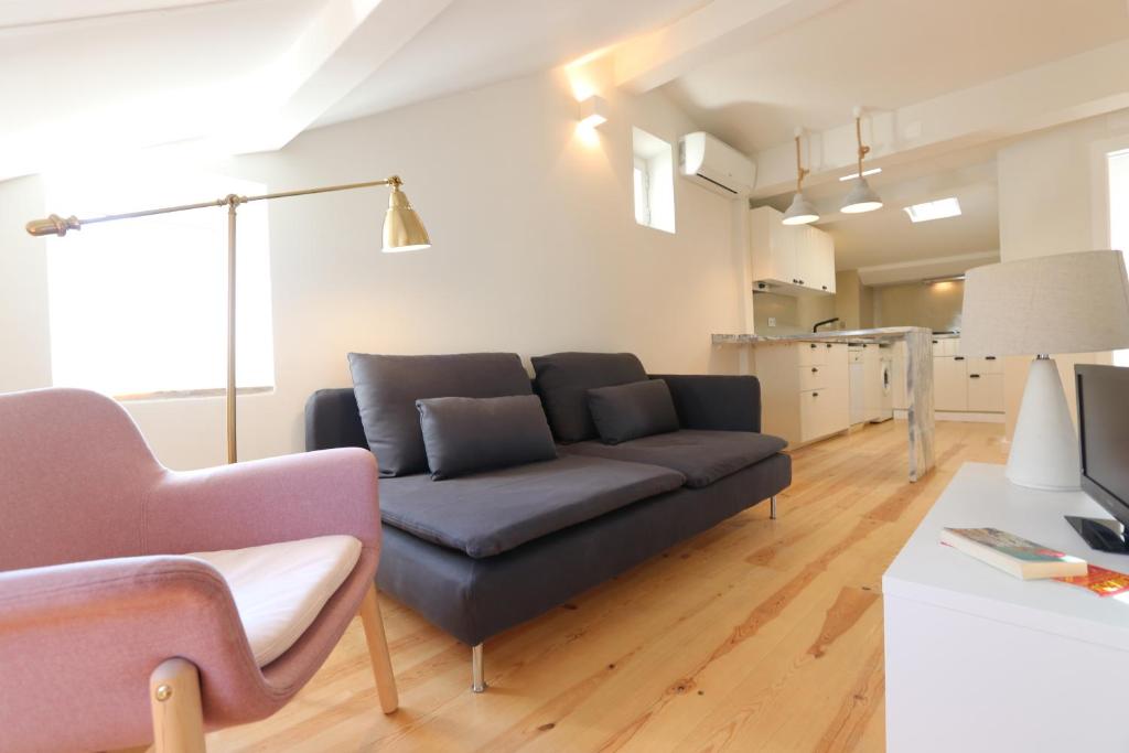 un soggiorno con un divano e un tavolo di The Romantic Nest - the Perfect Getaway at Downtown, 6th-floor no lift a Lisbona