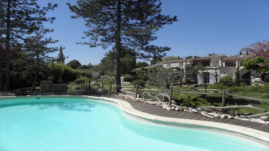 - une grande piscine dans une cour avec une maison dans l'établissement Gîte en Ardèche Méridionale - Les Berbéris, à Chandolas