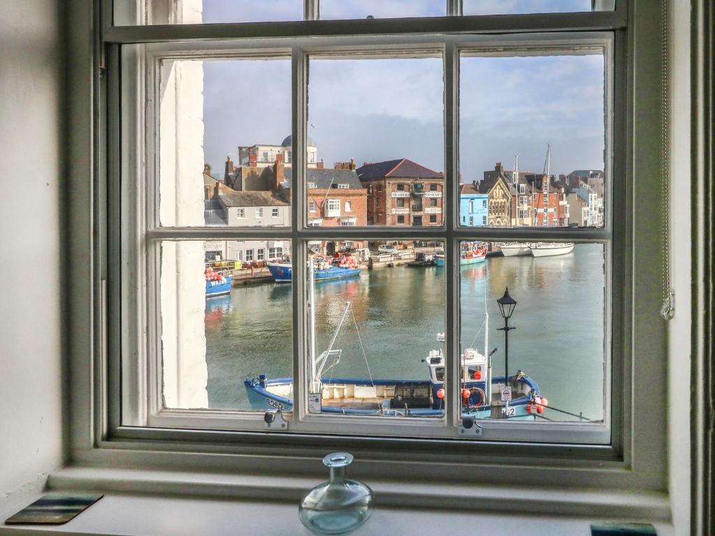 a window with a view of a boat in the water at Embassy in Weymouth