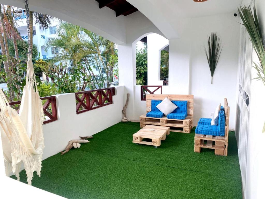 une terrasse couverte avec un hamac et un sol vert dans l'établissement Xarraca, à Bayahibe