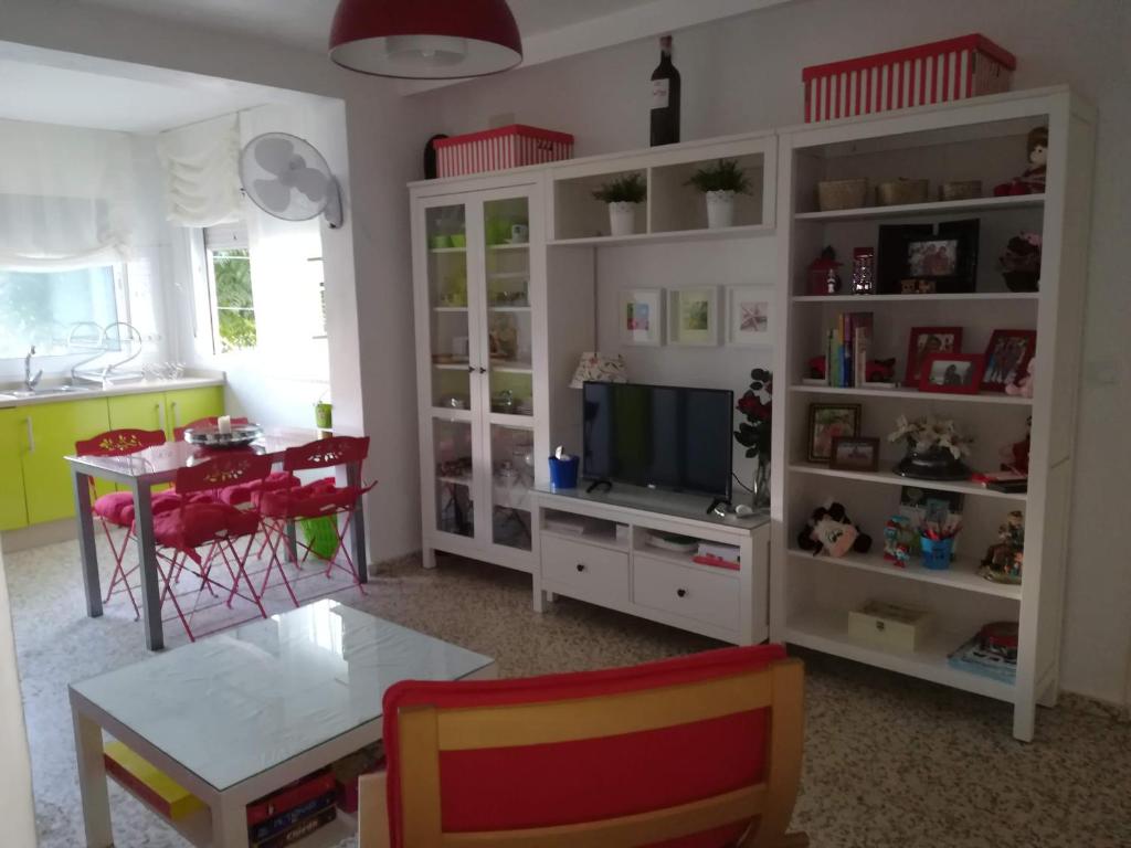 uma sala de estar com uma mesa e uma televisão em El Vigía Beach. Mazagón em Mazagón