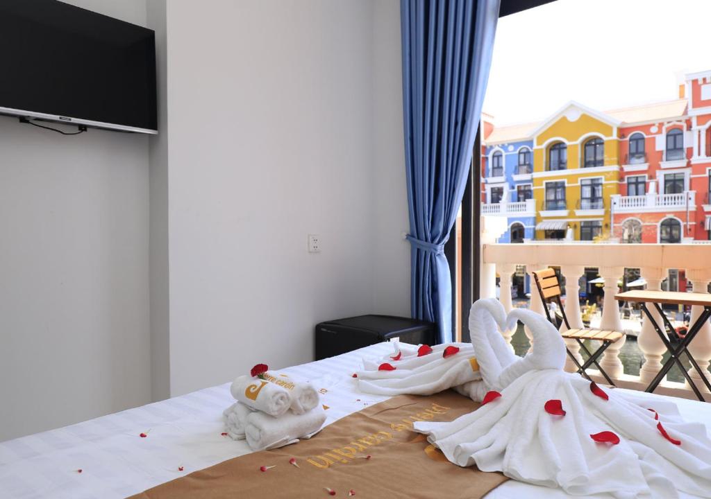 1 dormitorio con 2 decoraciones de cisnes en una cama en Venice River View P Boutique Hotel - Grand World Phú Quốc, en Phu Quoc