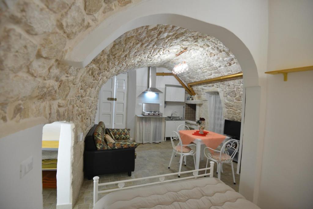 a living room with a table and a stone wall at B&B CASAVACANZE CHIESA MADRE in Carovigno