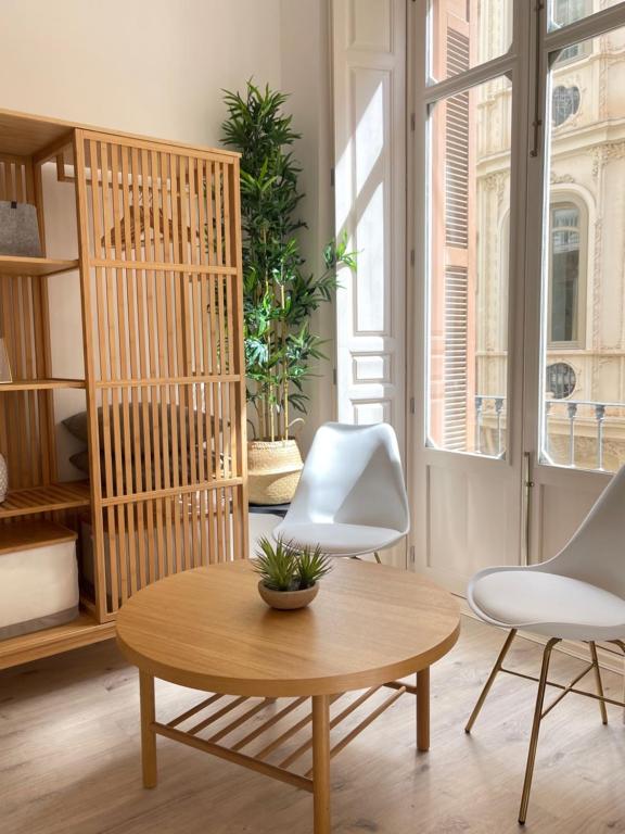 uma sala de estar com duas cadeiras brancas e uma mesa em CASA EULALIA em Málaga