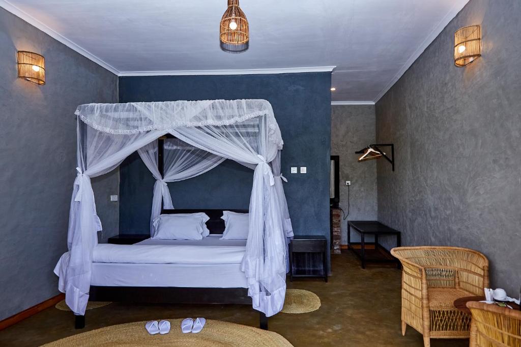 a bedroom with a bed with a canopy at Kutoka Lodge in Arusha