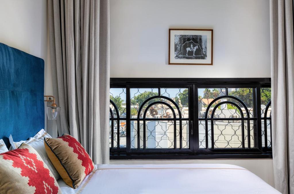 ein Schlafzimmer mit einem Bett und einem großen Fenster in der Unterkunft Kubler's House - By Beach Apartments TLV in Tel Aviv