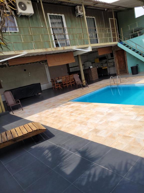 una piscina vuota con tavolo e sedie accanto a un edificio di Contconteiner hospedagem a Olímpia