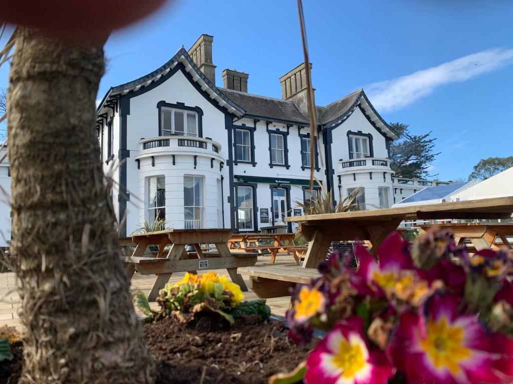 ein großes weißes Haus mit Blumen davor in der Unterkunft The Haven Hotel in Dunmore East